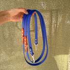 Laisse La Baroudeuse 2m30 en Biothane bleu électrique avec rappel orange Balise, deux mousquetons, tenue à la main